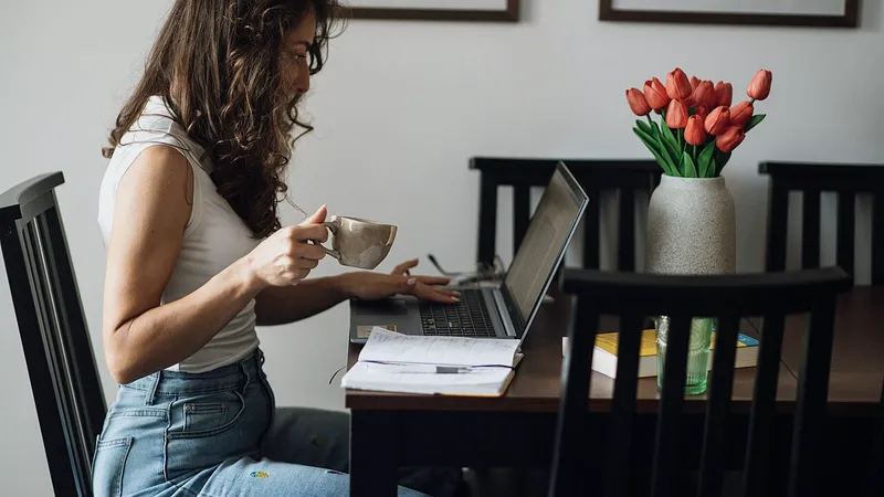 Woman working on a laptop at a home office desk